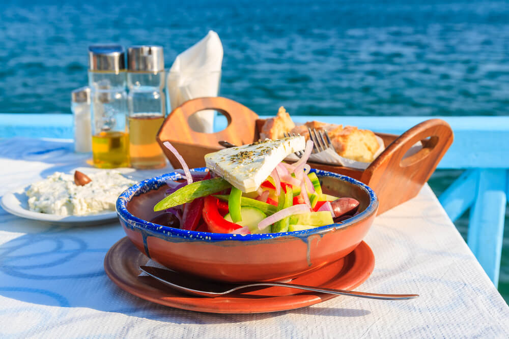 Greek salad on a table by the water 