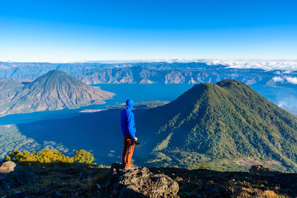 Hiker in blue jacked on top of the Guatemalan mountains 