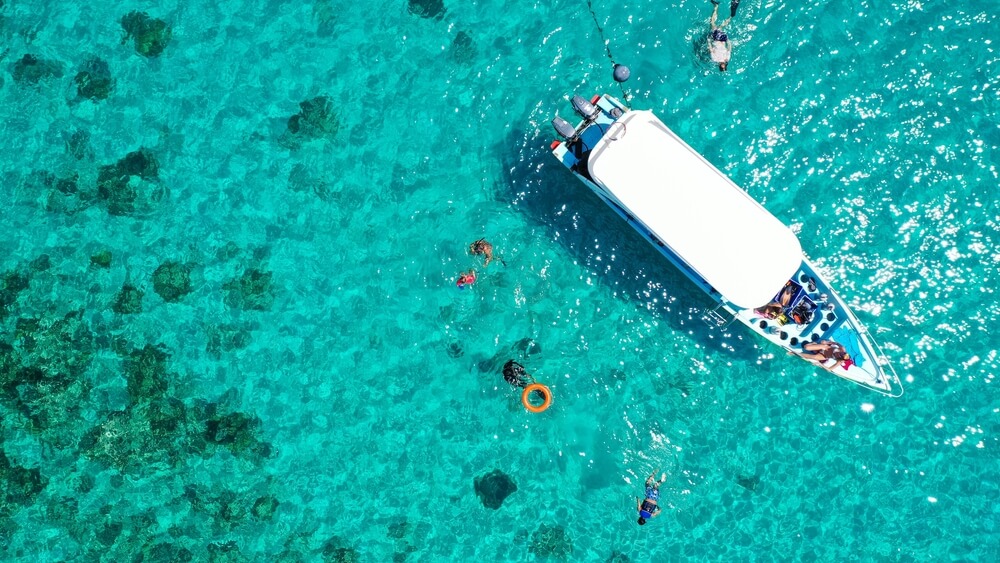 snorkelers near a boat in Rhodes, Greece