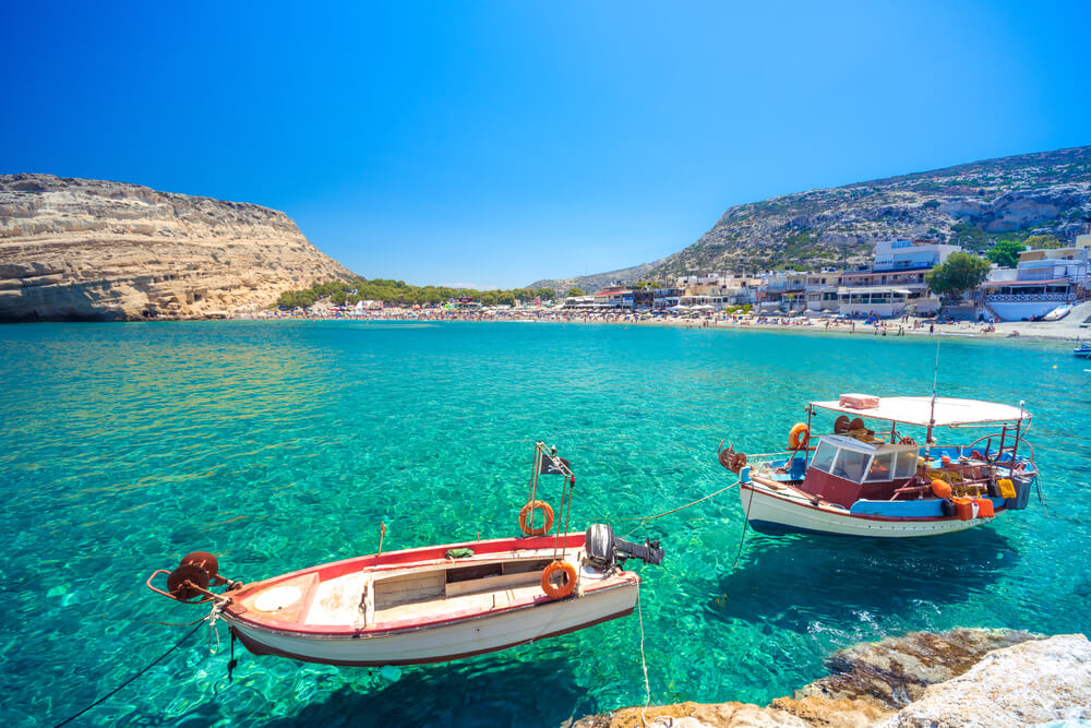 red and white boats floating on aqua water in Crete, Greece