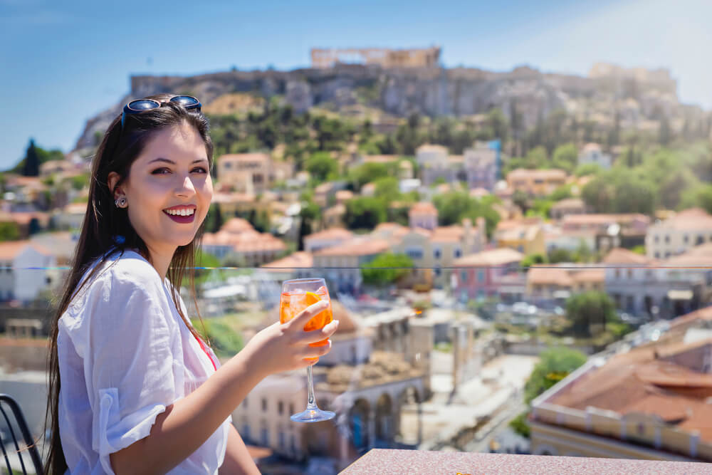 girl having a drink on a rooftop bar in Athens