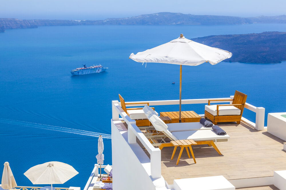 umbrellas and chairs over cliff  over Santorini