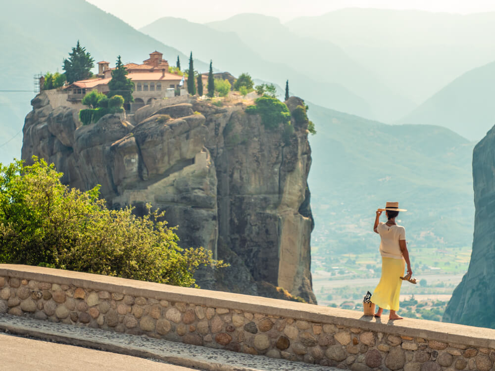 woman looking at a monastery in Meteora Greece