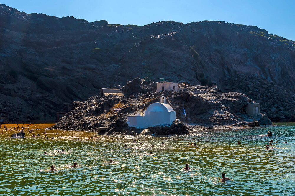 people swimming near church in Greece