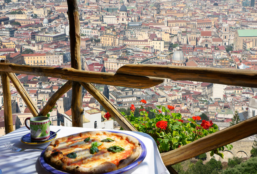 pizza on a table overlooking Naples in italy