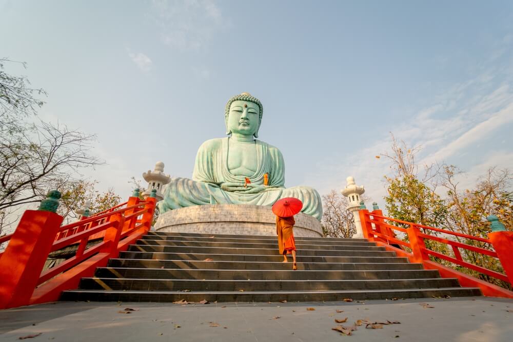 white Buddha with red flags in Northern Thailand 