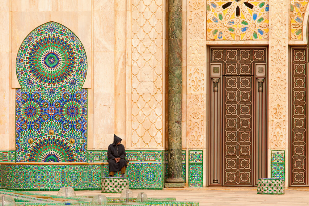 man sitting near colorful archway 