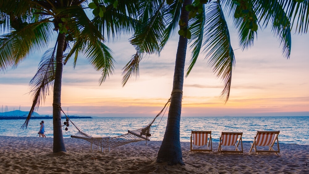 palms and lounge chairs on Pattaya Beach Thailand