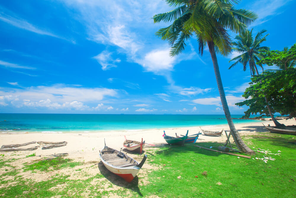 beach with fishing boats in Thailand