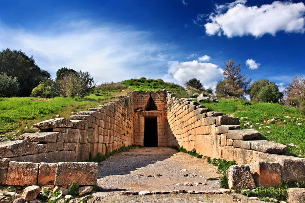 treasury walls of a Unesco site in Greece with blue skies and green grass